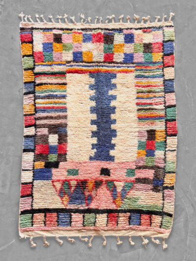 Alfombra bereber Boujad 13:26, campo crema con columna azul escalonada, damero multicolor y flecos anudados, 152 x 210 cm