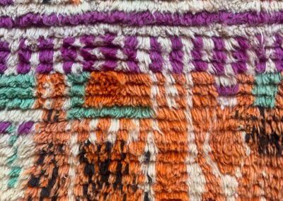 Boujad New Works Moroccan rug: close-up of the long wool pile in orange, fuchsia, sea green and ecru. Detail.